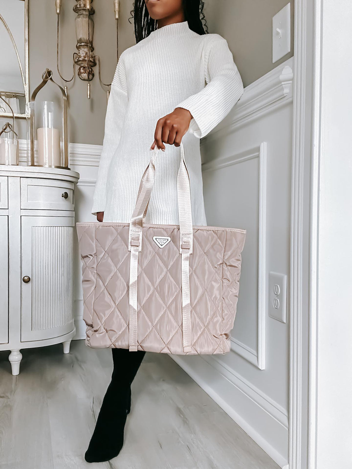 Blush quilted designer tote styled with a white knit dress and black boots.